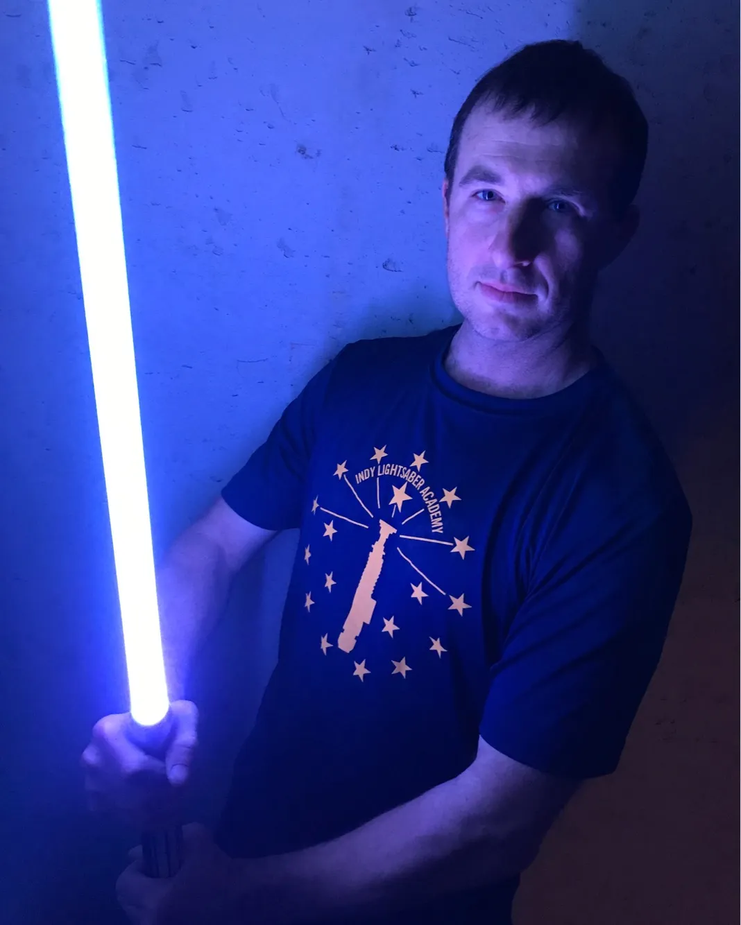 James Keith holding an illuminated lightsaber.