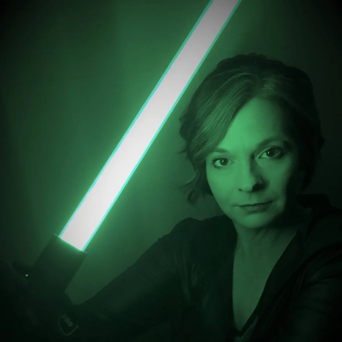 Kelly Snyder holding an illuminated lightsaber.